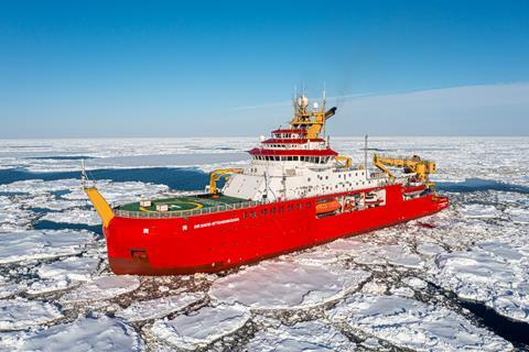 The RRS Sir David Attenborough with its bright red hull sailing through broken ice