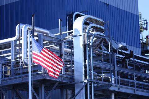 An image showing a factory and a US flag
