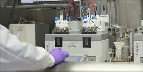 Scientist using reaction apparatus in lab