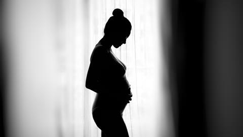 An image showing the silhouette of a pregnant woman