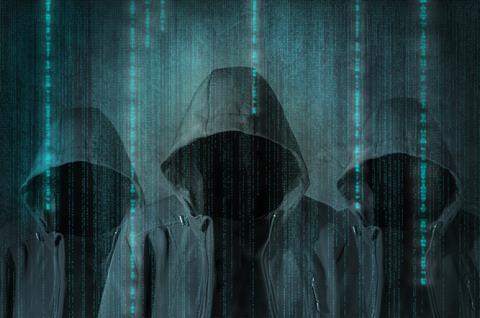 Three hooded figures with computer imagery