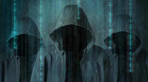 Hooded figures with computer imagery in the background