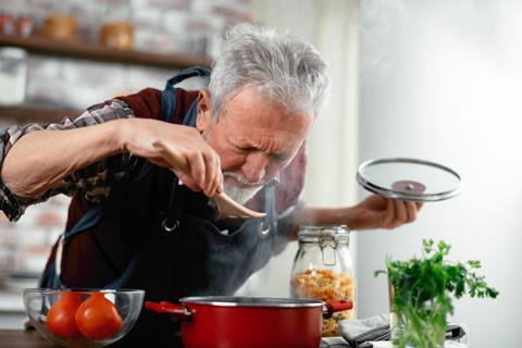 Old man smelling freshly cooked food