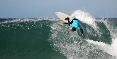 A photograph of a surfer riding a wave