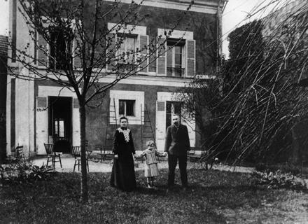 Marie and Pierre Curie standing outside their family home with daughter Irene