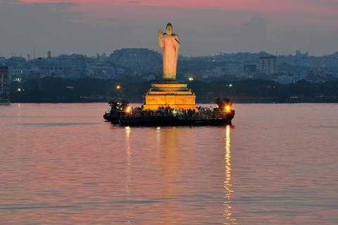 Buddha statue at dusk in Hussain Sagar in Hyderabad, India.