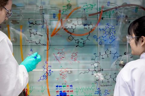 People writing on fumehood with marker pen