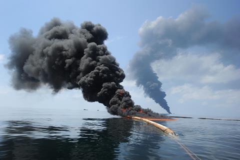 An image showing dark clouds of smoke and fire emerging as oil burns during a controlled fire in the Gulf of Mexico
