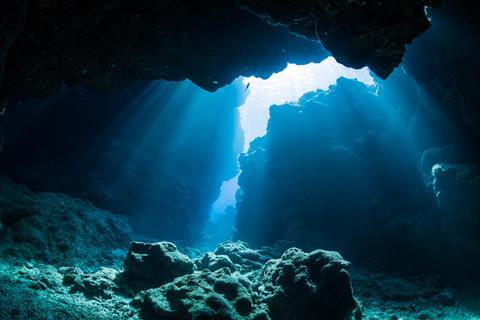 A photograph showing a ray of sunlight in an underwater cave
