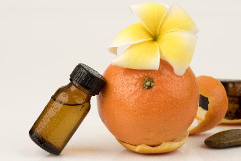 A photograph of orange peel and a bottle of essential oil