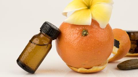 A photograph of orange peel and a bottle of extract