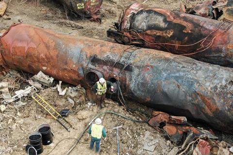 Aerial shot of two workers among some severely burnt rail tank cars