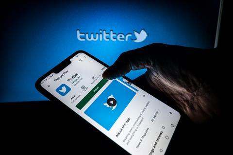 An image showing the Twitter logo and a phone with the Twitter app displayed on the screen