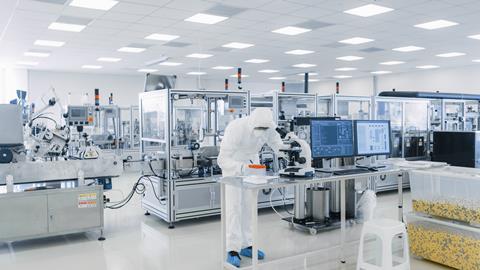 Sterile pharmaceutical manufacturing laboratory, researchers in PPE