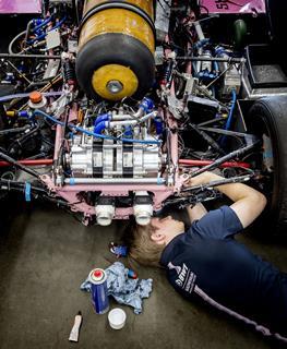 An image showing a student from TU Delft working on a self-built hydrogen racing car Forze VIII on the future Formula 1 circuit in Zandvoort