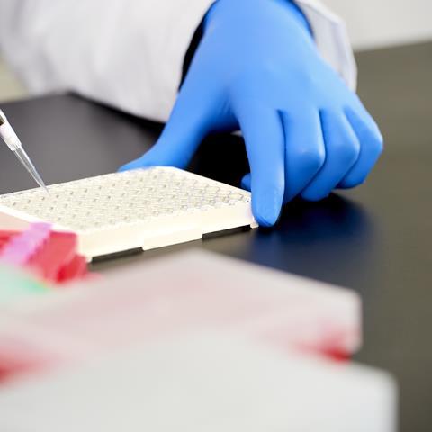 Scientist pipetting liquid into vials