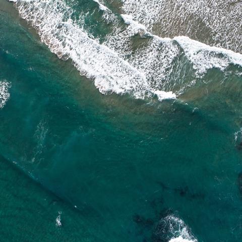 Ocean waves along the shoreline from an overhead view