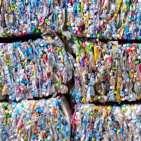 A photo of hundreds of plastic bottles, squeezed together to form space-saving cubes