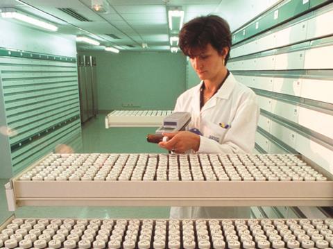 Female scientist using bar-code reader in a drug molecule library
