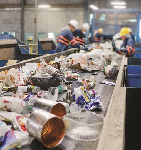 Mixed recycling on conveyor belt to be sorted by workers 