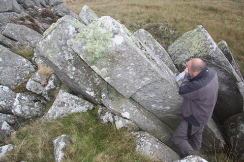 Professor Nick Pearce uses a handheld spectrometer to analyse rocks at at Carn Goedog in Wales, a source of some of the other Bluestones at Stonehenge