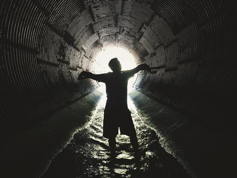 An image showing a silhouette of a man inside a sewer 