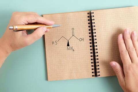 Cysteine with left handed hand holding pen