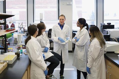 Scientist leading meeting in laboratory