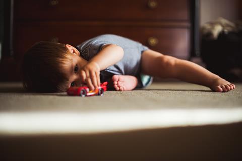 infant playing with toy cars