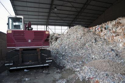 Wood and paper pulp piled next to machinery in a warehouse