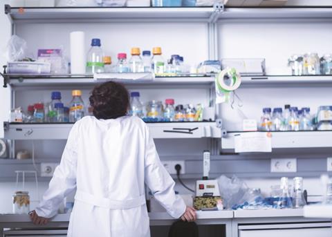 Female scientist in laboratory looking at shelves