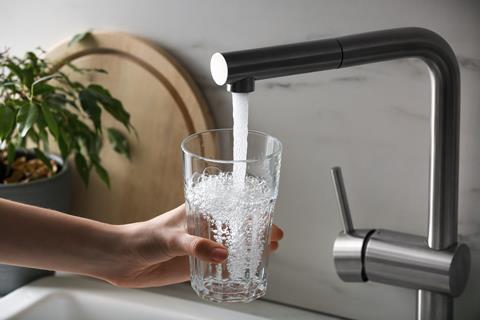 Tap water pouring into a drinking glass