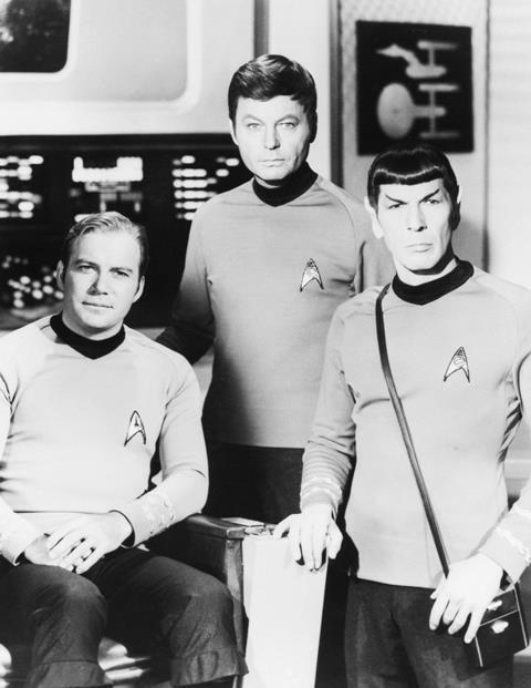 William Shatner, DeForest Kelley, and Leonard Nimoy posing together in their Stark Trek costumes