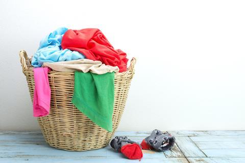 Clothes in a laundry wooden basket on wood table