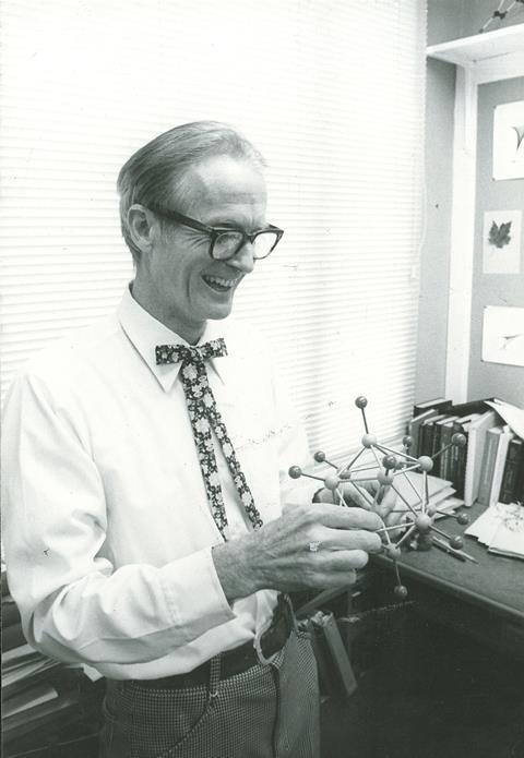 William Lipscomb holding a chemical model