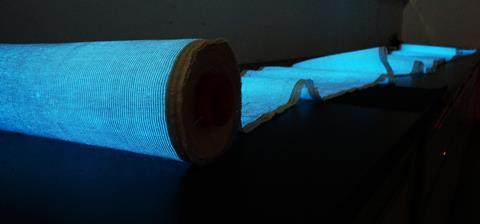 A photo of a role of material with a blue glow