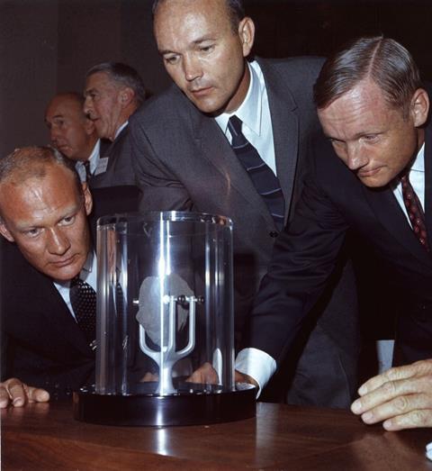 An image showing the Apollo 11 crew looking at a lunar sample
