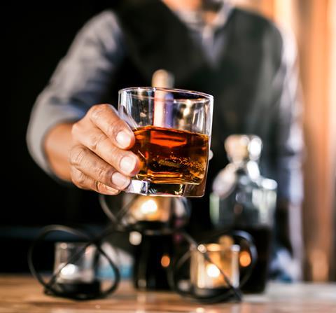 Man holding a glass of whiskey