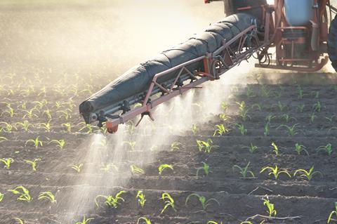 Tractor spraying crop