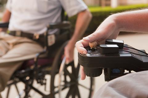 DMD patient manipulates controls on electric wheelchair