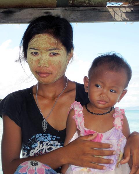 Sama woman with traditional sun protection or 'borak', Maiga Island, Semporna, Malaysia