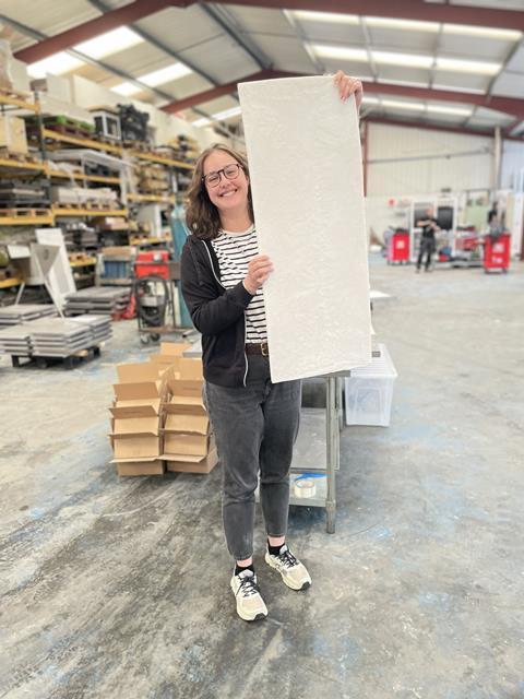 Co-founder Tara Love holds a board of insulation material