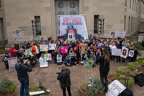 Protestors with banners objecting to protections offered to the Sackler family in Purdue's bankruptcy settlement