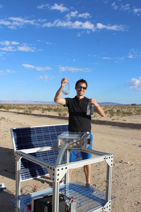 An image showing Mathieu Prévot displaying water collected by the harvester in the Mojave Desert