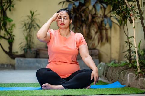An image showing an Indian woman practicing pranayama