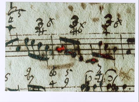 A musical score with holes from iron gall ink corrosion