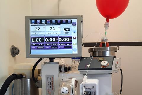 Science equipment with a red balloon and a screen.
