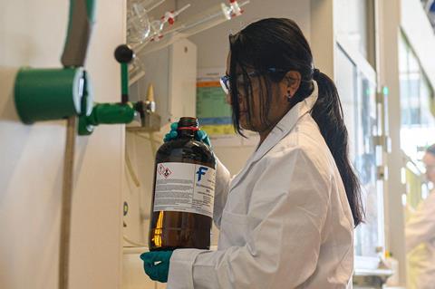 Researcher holding a bottle of DCM