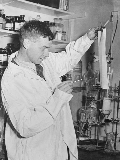 Dr Richard Laurence Millington Synge looking at some paper in a lab