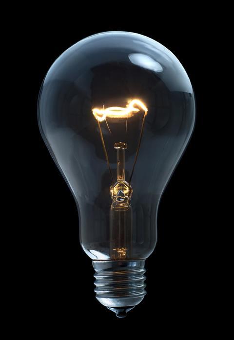 A incandescent light bulb on black background